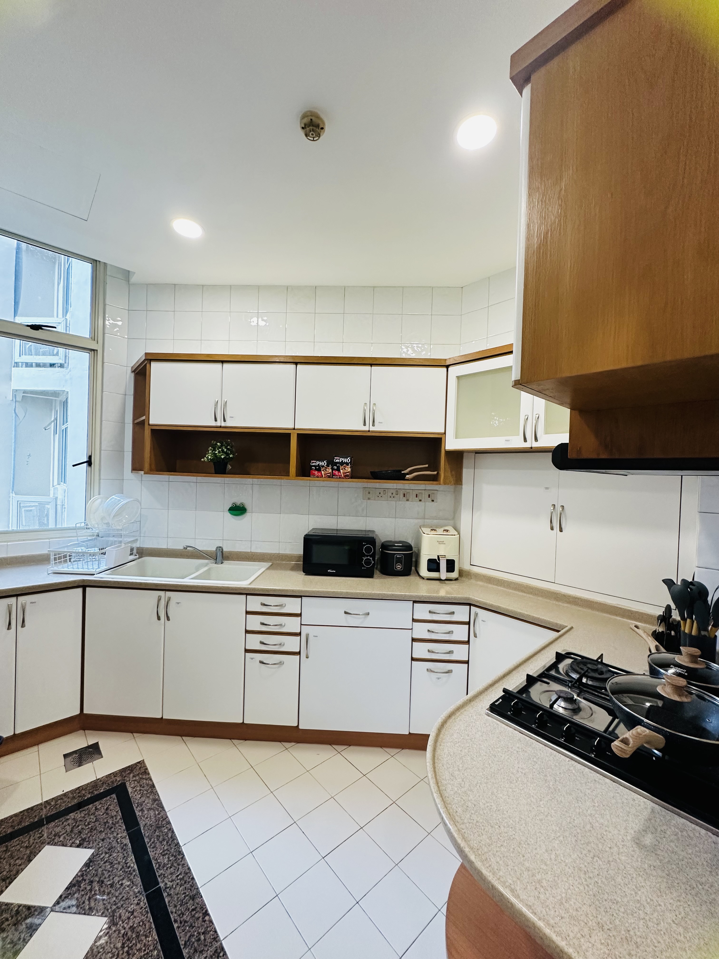Shared kitchen at Harvest Mansions — cabinets, sink, gas hob and microwave