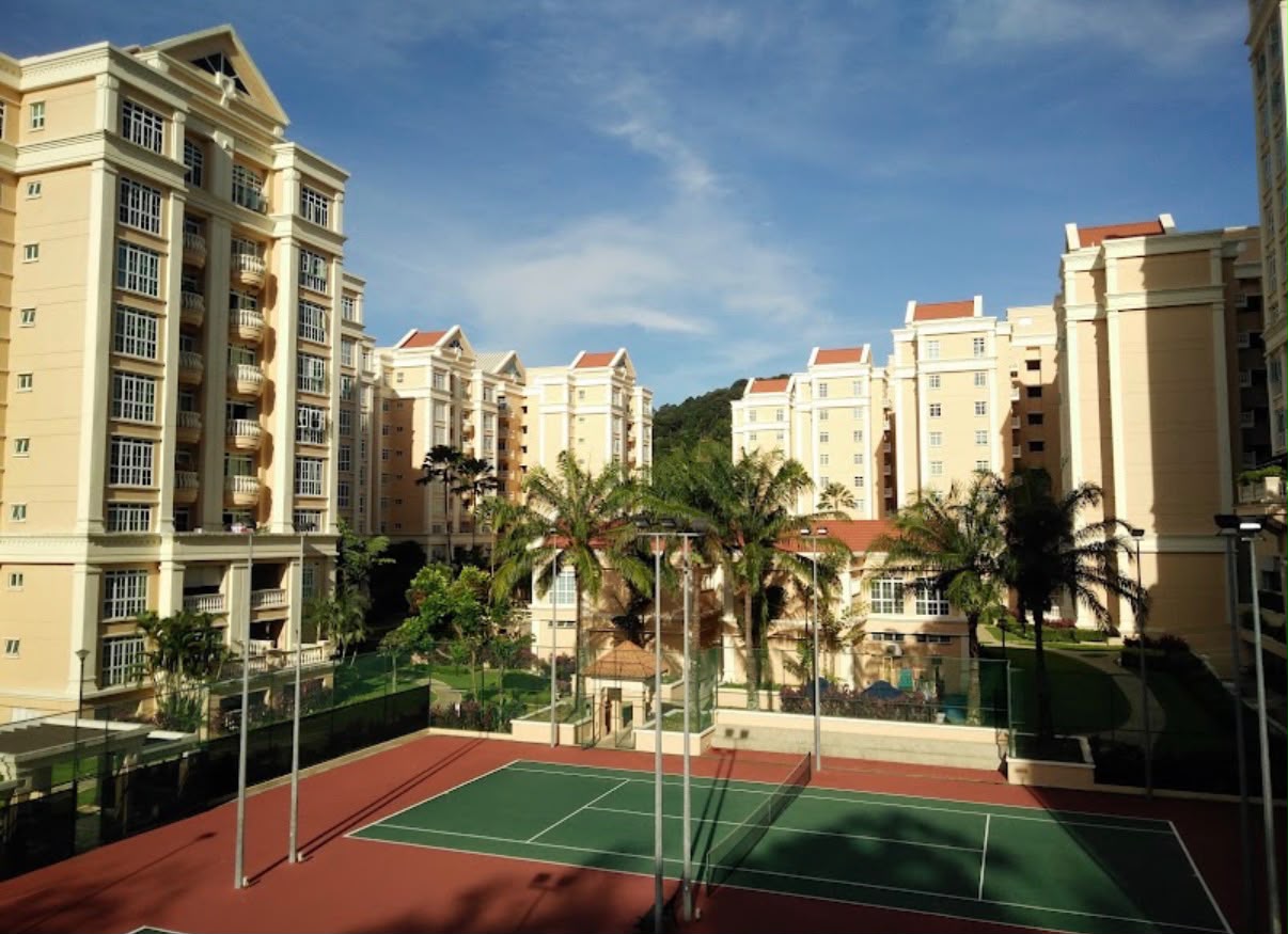 Symphony Heights condominium towers and tennis court under a blue sky