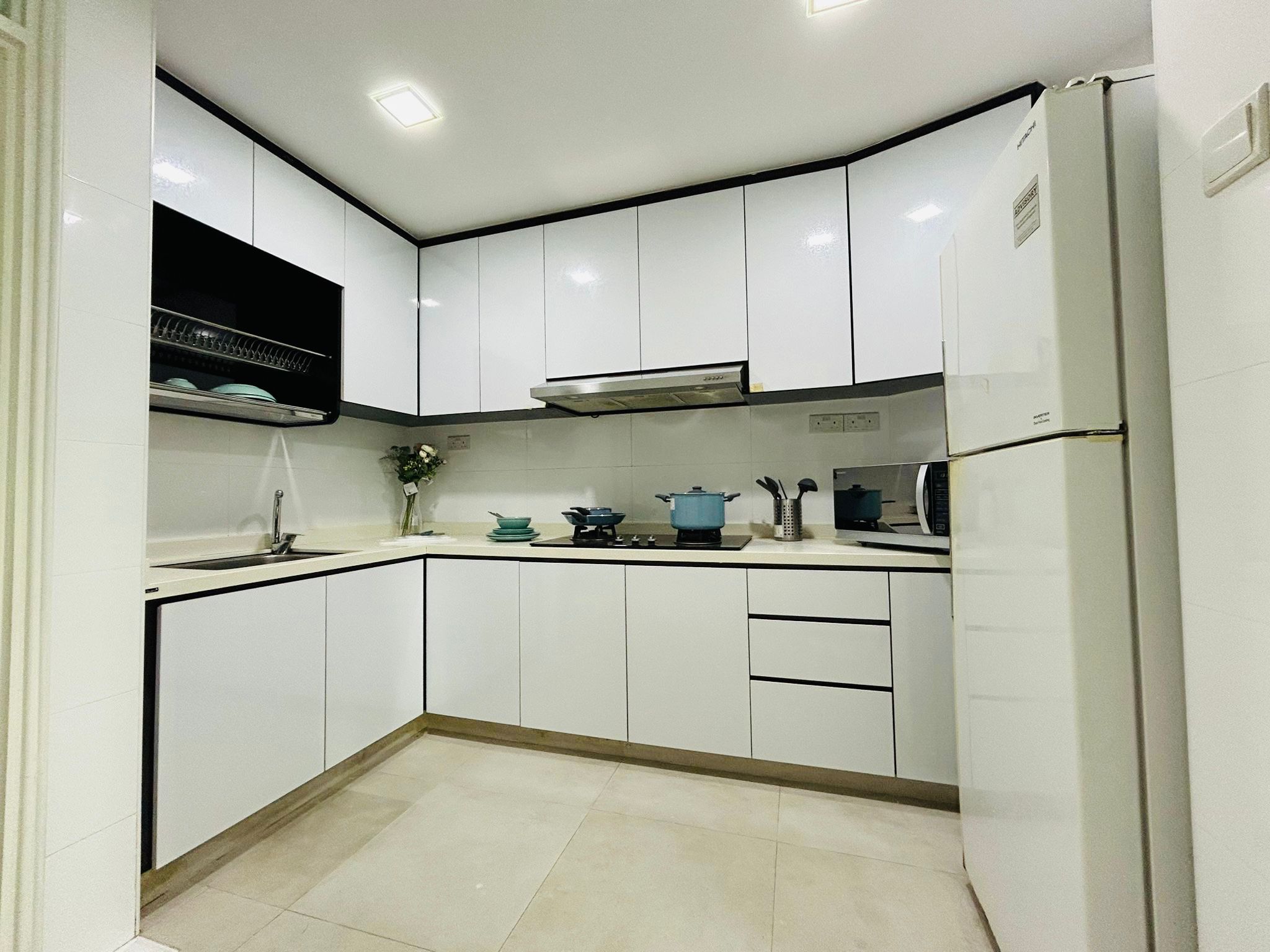 Shared kitchen at Orchid Park 1 — white cabinets, hob and fridge